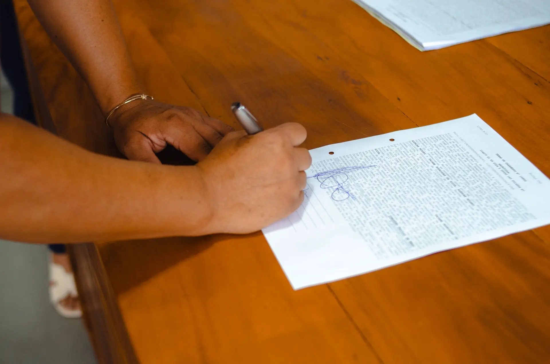 Primer plano de una mano firmando un documento legal