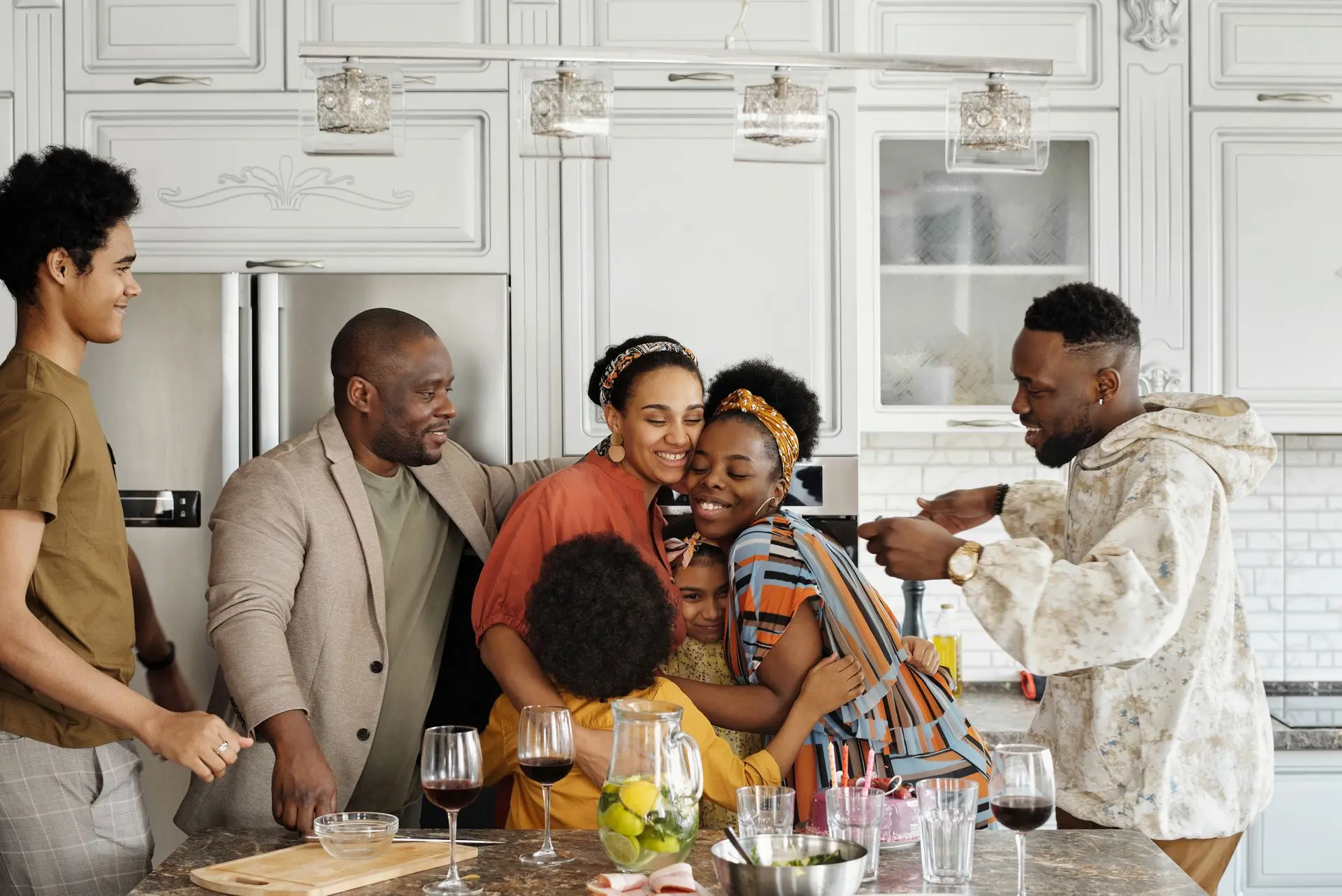 Familia abrazándose emocionada en la cocina tras reunirse de nuevo